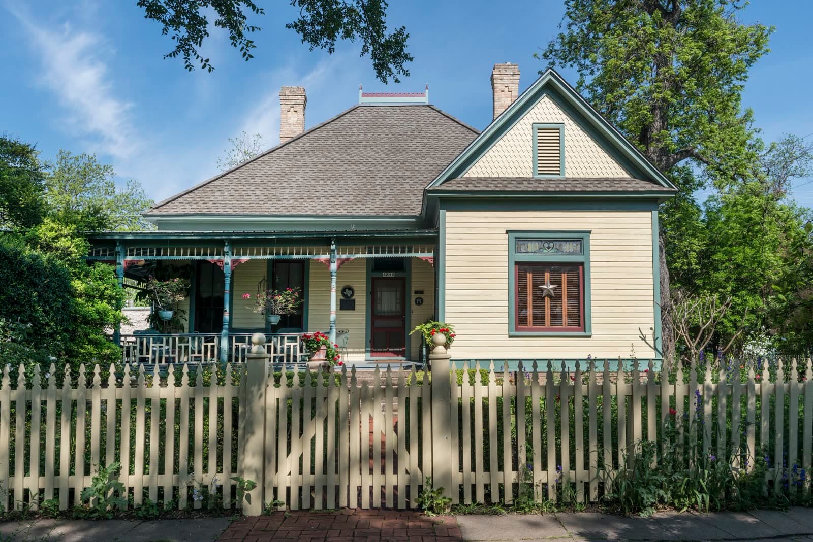A gabled Hyde Park cottage behind mature trees
